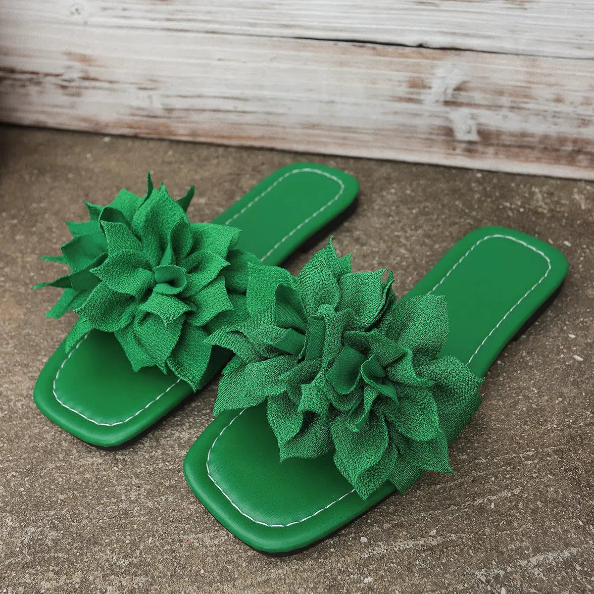 Flat flip-flops with flower decoration in faux leather and rubber sole in black colour for women