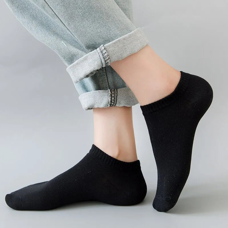 Solid colour men's low cut socks in black, grey, and white with seamless toe construction and blended fabric for breathability.
