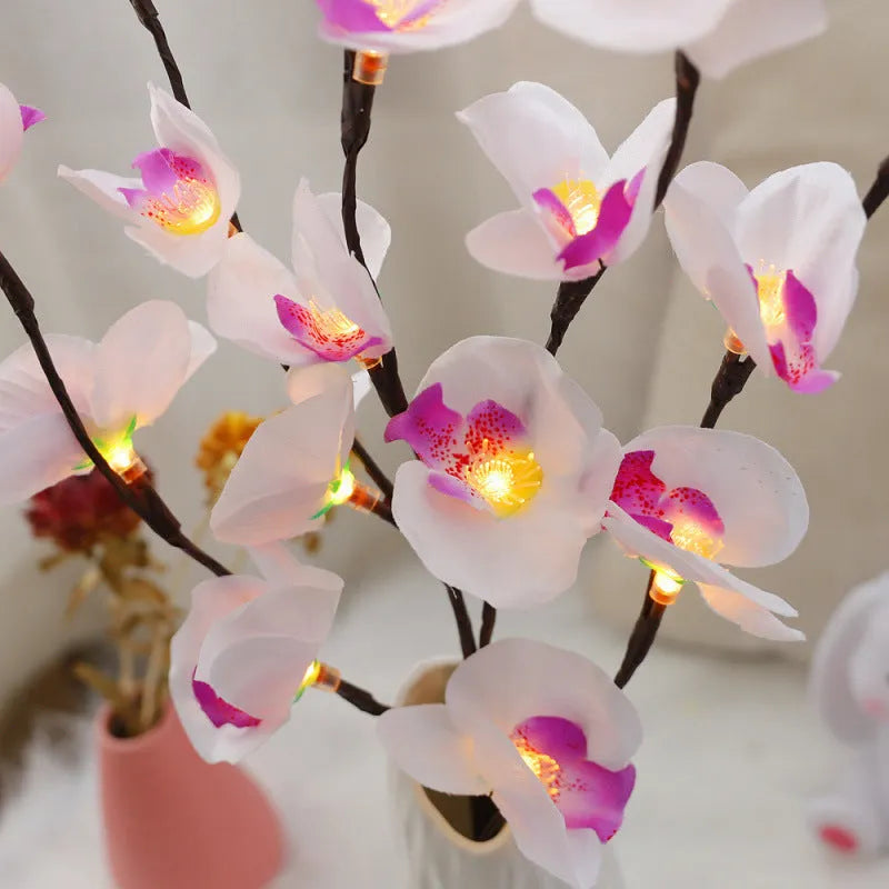 Pink LED Phalaenopsis branch decorative light on a table, 65cm long with fabric cover.