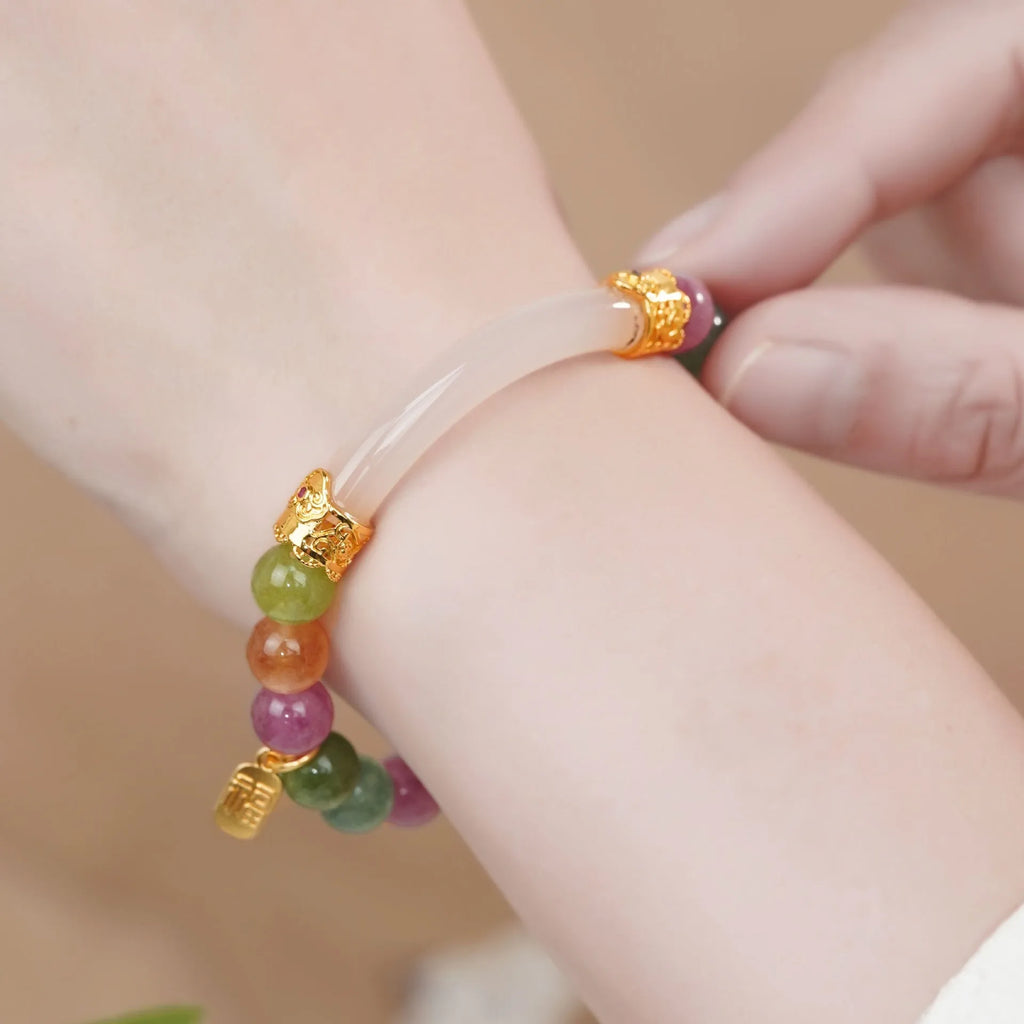 Rainbow colour tourmaline half bracelet for women on a wrist.