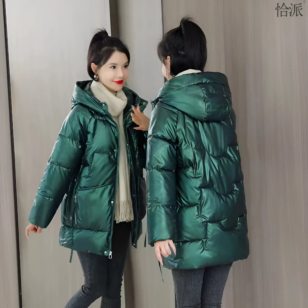 Woman wearing a loose-fit green hooded winter jacket with long sleeves.