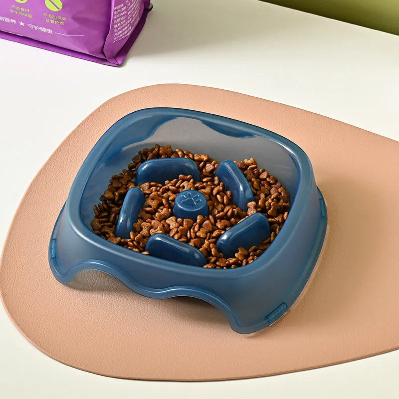 Blue plastic slow feeder dog bowl for anti-choking feeding on a plain surface.
