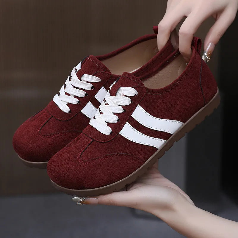 Women's vintage canvas sneakers in dark red with a soft rubber sole and round toe.