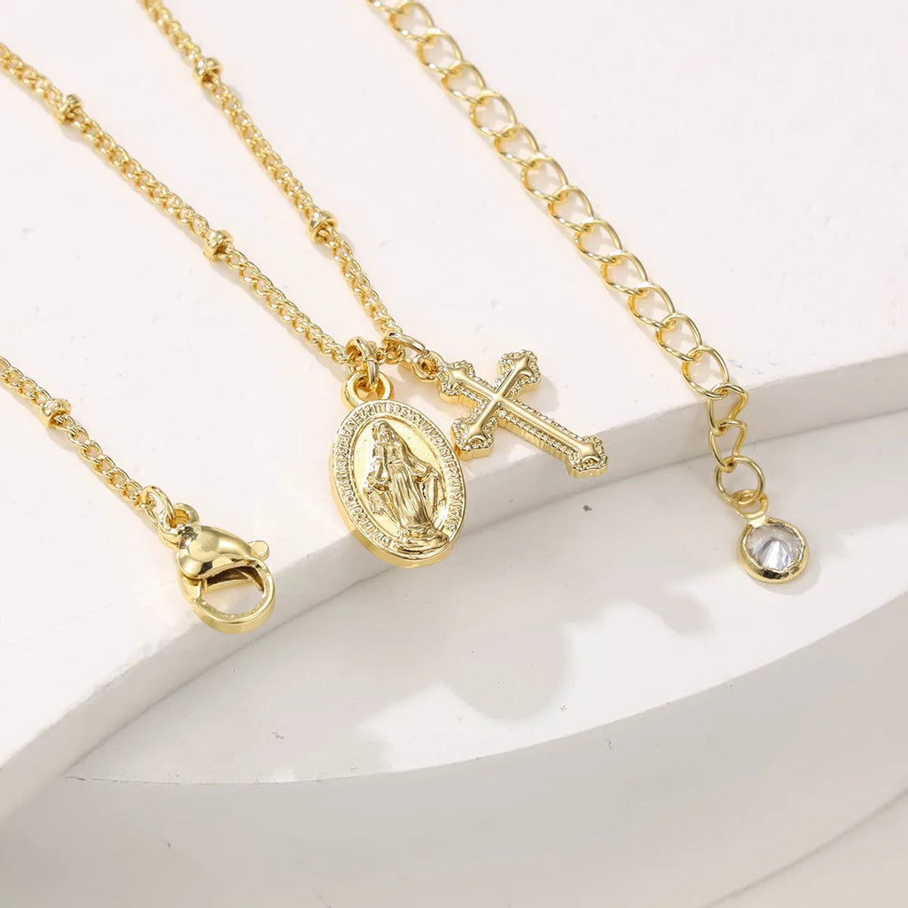 Geometric Cross Virgin Mary pendant necklace in gold on a simple chain.