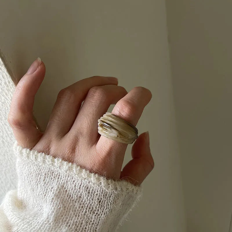 Chinese style irregular geometric resin wide ring in neutral colours on display