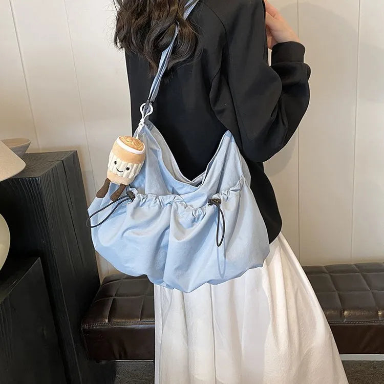 Ultra-light pleated foldable crossbody bag in beige, showing split pocket and crossbody strap.