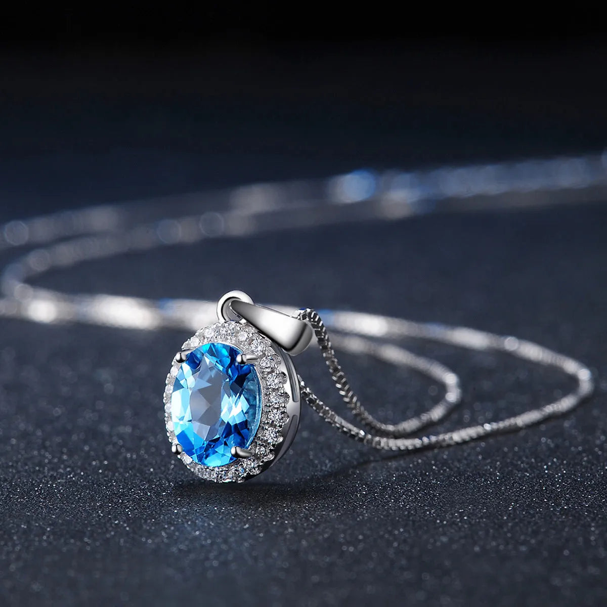 Women's 925 silver blue topaz jewellery set showing geometric earrings, ring, pendant and necklace.