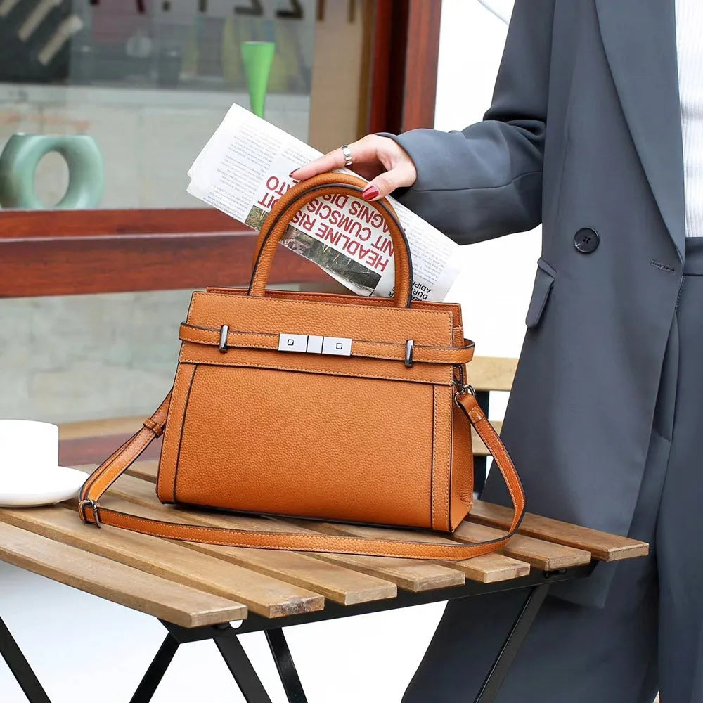 Genuine leather small square shoulder bag in almond green showing external pocket and stitching detail.