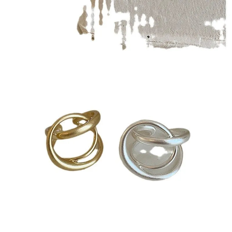 Geometric open ring with three-dimensional interlaced metal design in gold or silver colour