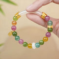 Rainbow colour tourmaline half bracelet for women on a wrist.