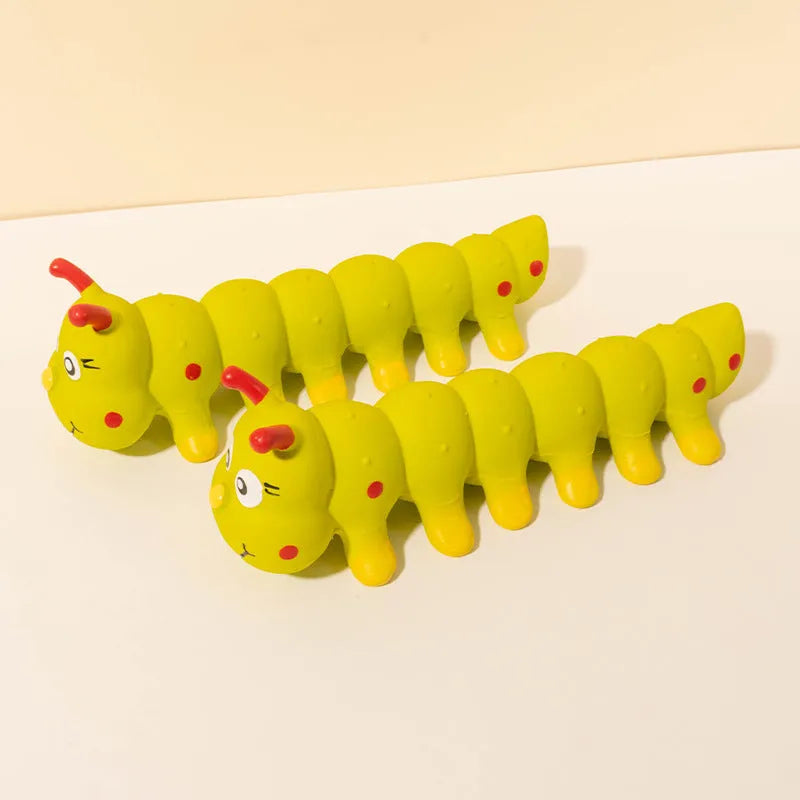 Yellow caterpillar-shaped rubber dog squeaky chew toy on a white background.