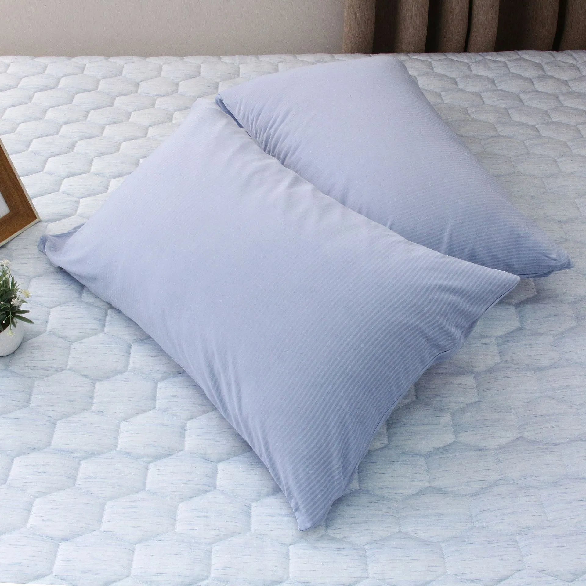 A blue polyester cooling blanket with Q-Max 0.4 technology laid on a bed.