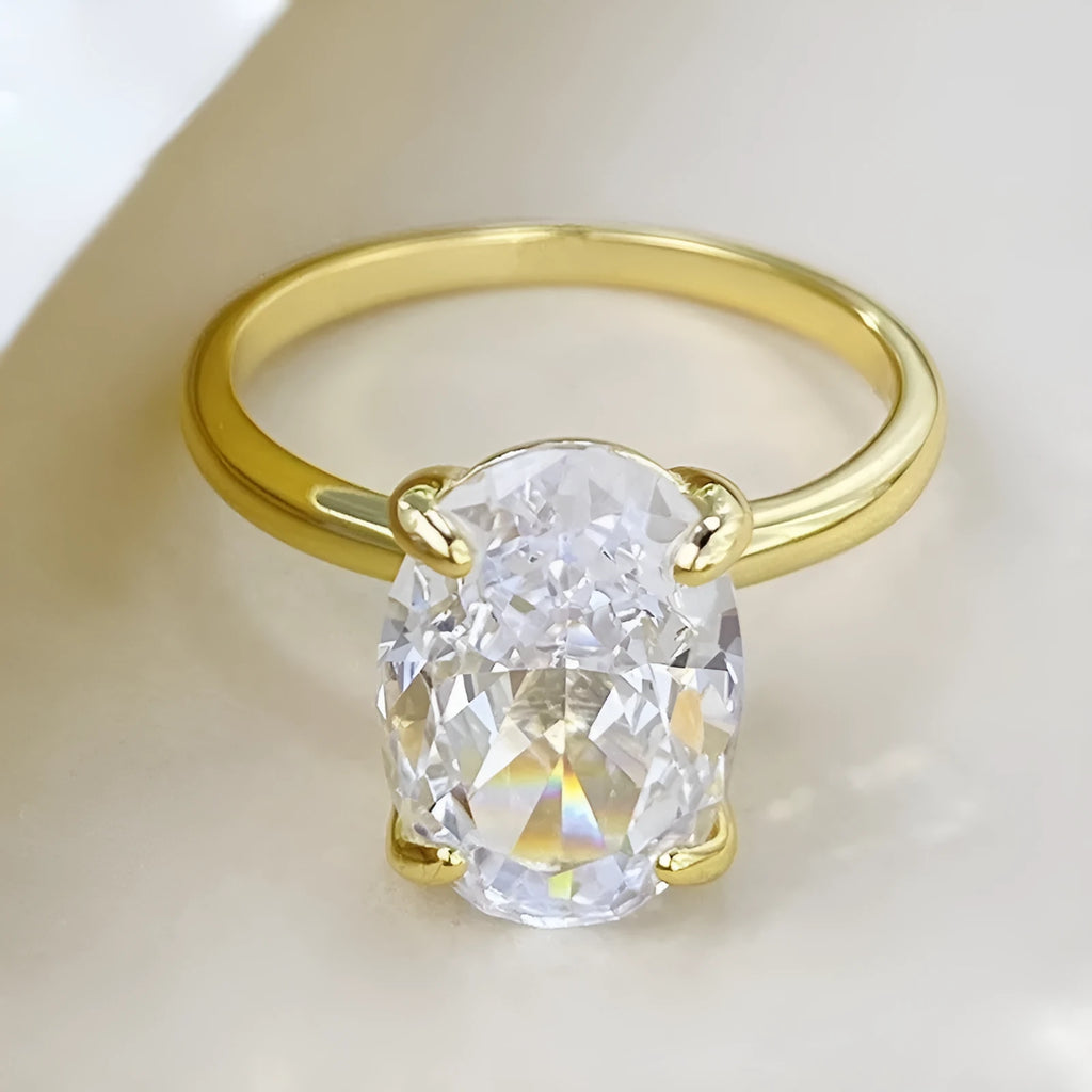 Women's oval four-claw solitaire ring with 6x9mm gemstone in gold or silver finish