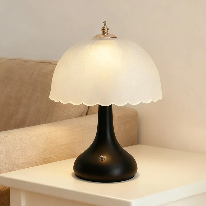 Geometric 3D table lamp in black with warm light on a wooden side table in a modern living room