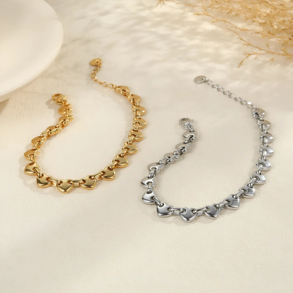 Stainless steel women's bracelet with a hollowed-out heart charm in gold or steel colour.