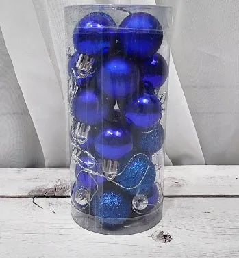 Assorted 3cm shiny gold, red, and silver Christmas ball ornaments spilling from a tall storage barrel.