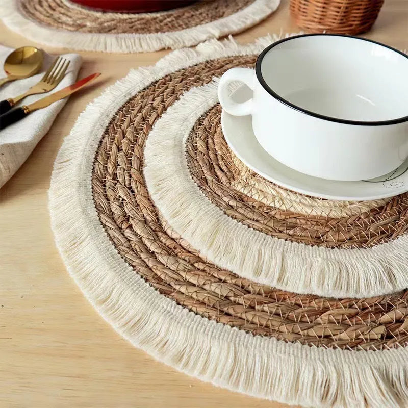 Round Japanese straw placemat with corn rope tassel detailing on wooden table