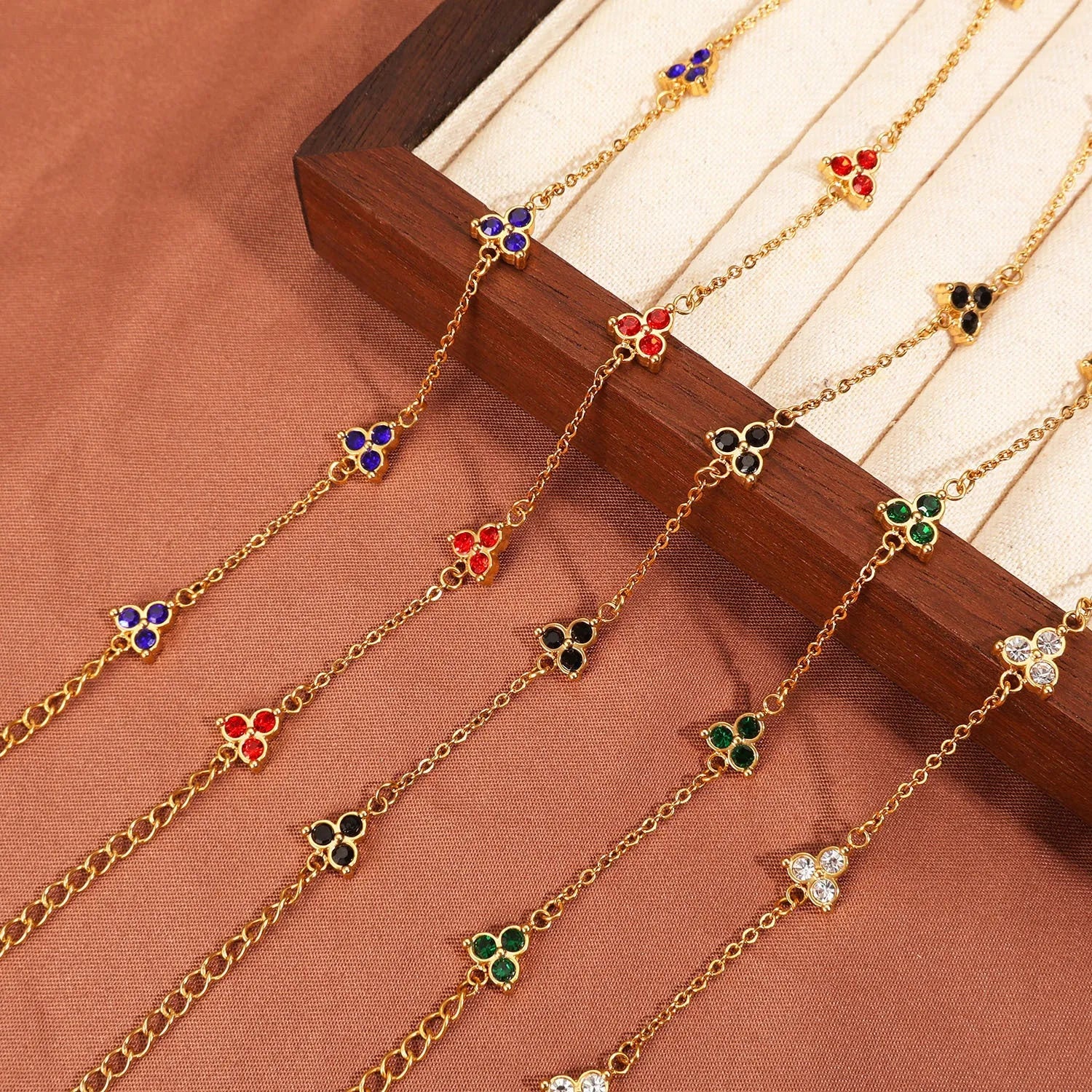 Women's stainless steel geometric bracelet with triangle design and three-diamond centrepiece in gold or steel finish.