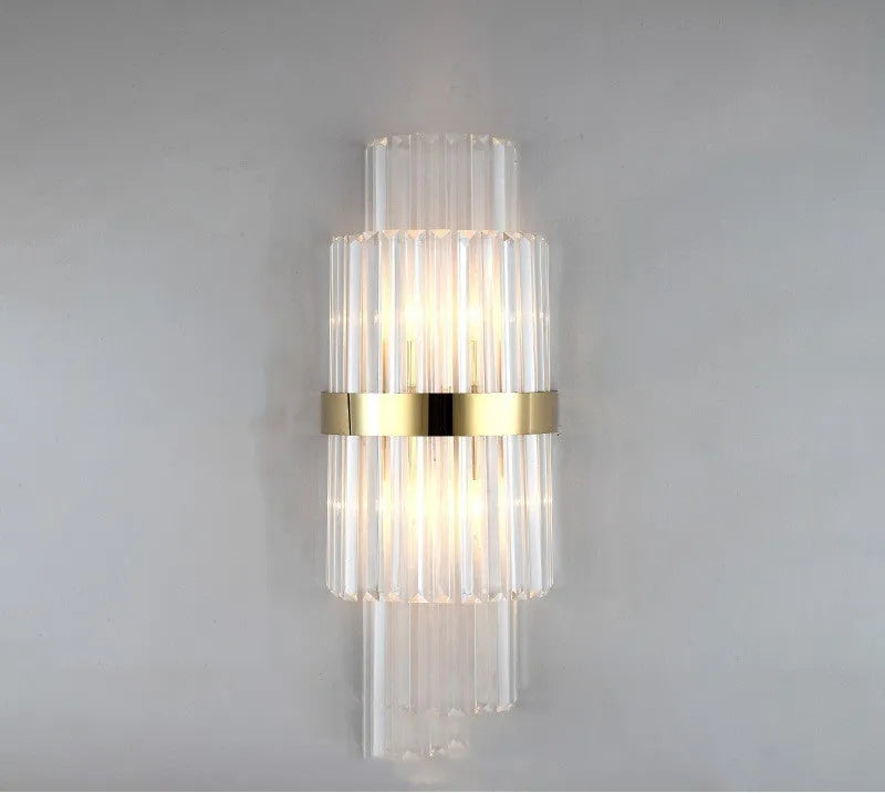 Modern crystal petal-shaped wall lamp in titanium gold finish mounted on a light-coloured wall.