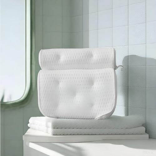 White 3D bathtub pillow with mesh fabric and suction cups on a bathtub edge.