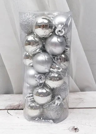 Assorted 3cm shiny gold, red, and silver Christmas ball ornaments spilling from a tall storage barrel.
