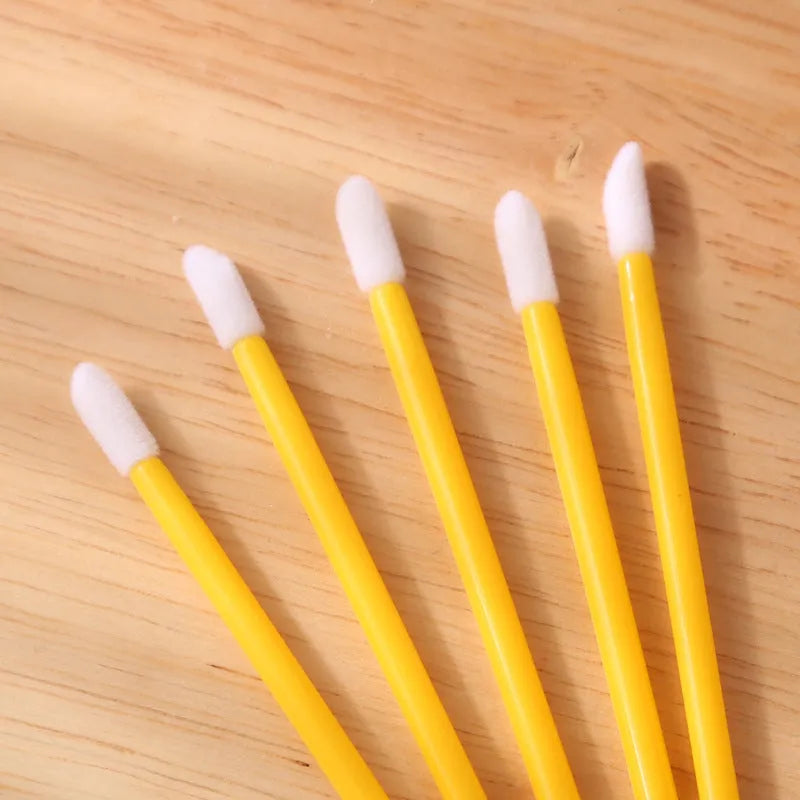 Pack of disposable lip brush applicators with coloured handles and flocked brush tips on a white background