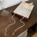 Gold-coloured women's hairpin with pearl diamond flower decoration and tassel detail