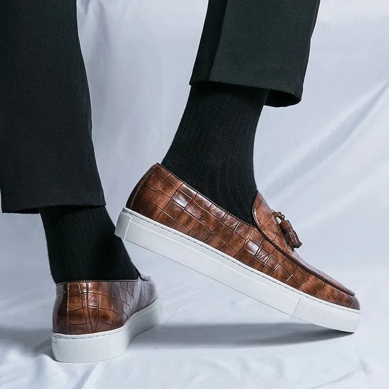 Men's plus size black slip-on sneakers with tassel detail and round toe on a rubber sole.