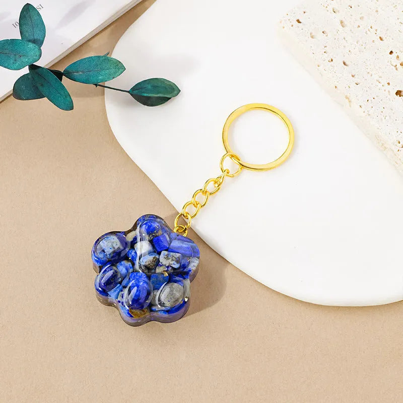 Small natural crystal cat's paw keychain pendant on a metal ring.