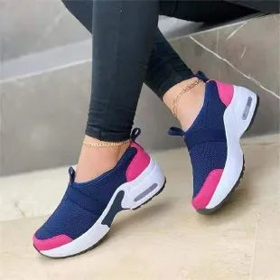Women's white mesh flat sneakers with round toe and colour stitching on a rubber sole.