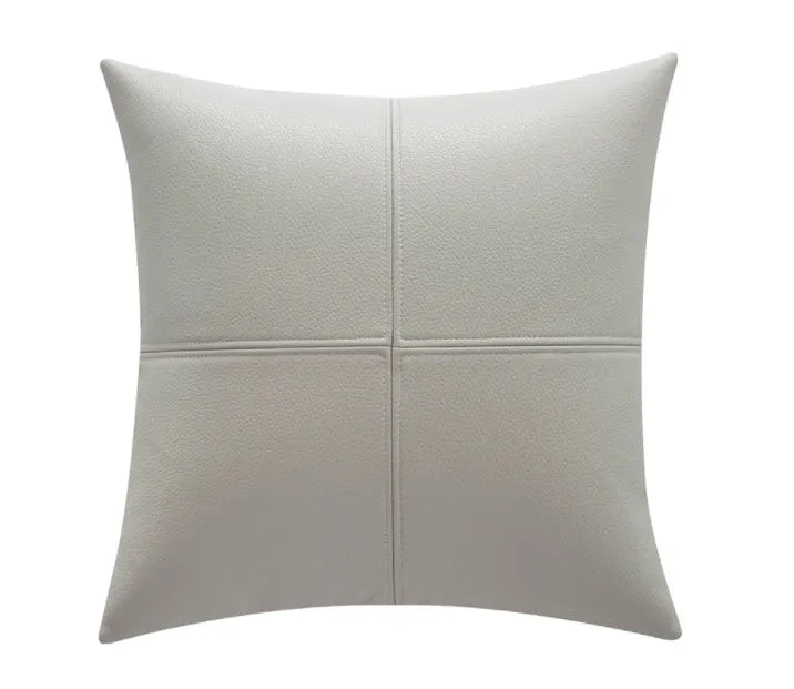 Simple solid colour cowhide leather pillow cover on a sofa, shown in a beige white colour.
