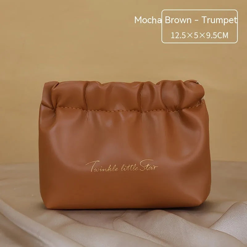 Large leather travel toiletry bag open to show dry and wet separation compartments.