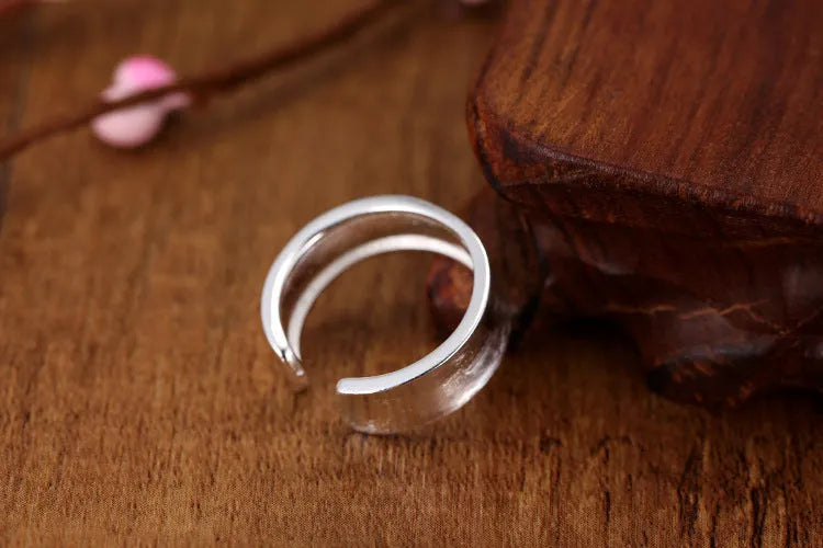 Open geometric ring in frosted sterling silver with an adjustable band.