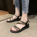 Women's silver flat sandals with rhinestone decoration and an elastic band, showing the round toe and rubber sole.