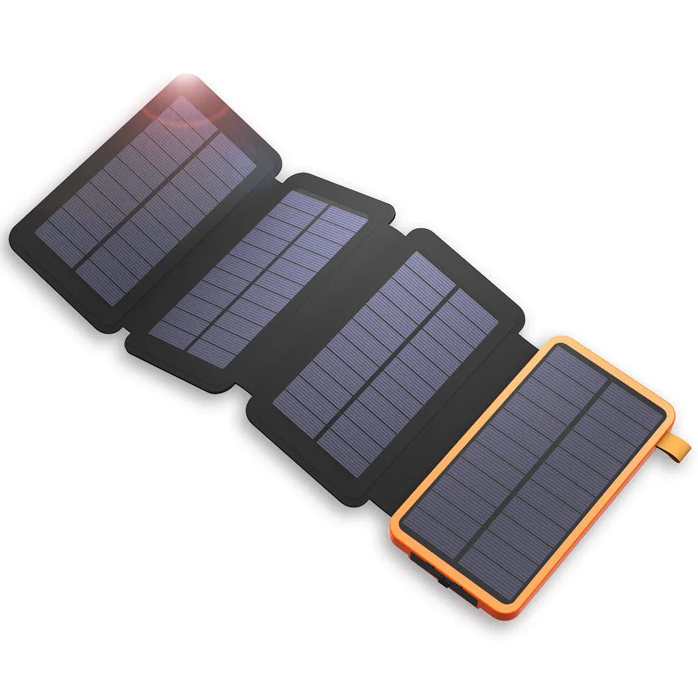 Black solar power bank with a solar panel, showing its USB ports and LED light, placed outdoors on a rock.