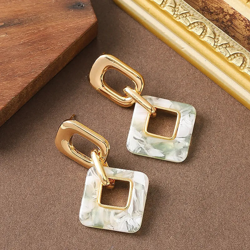 A pair of hollow geometric square earrings with chamfered corners in an electroplated copper finish.