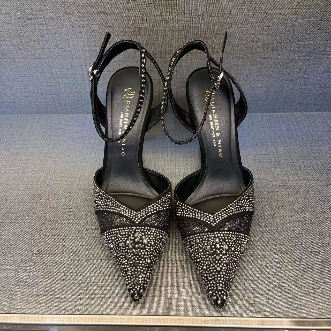 Women's black and silver hollow high heels with red soles, stiletto heels, and pointed toe design