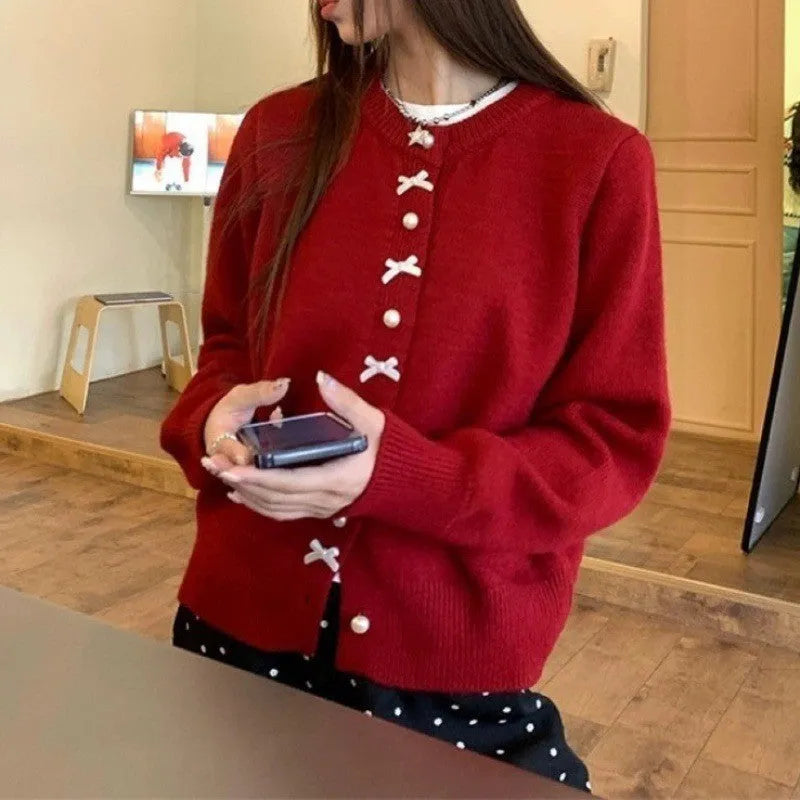 Women's solid colour cardigan with bow and pearl buttons, cashmere acrylic blend, shown in multiple colour options.