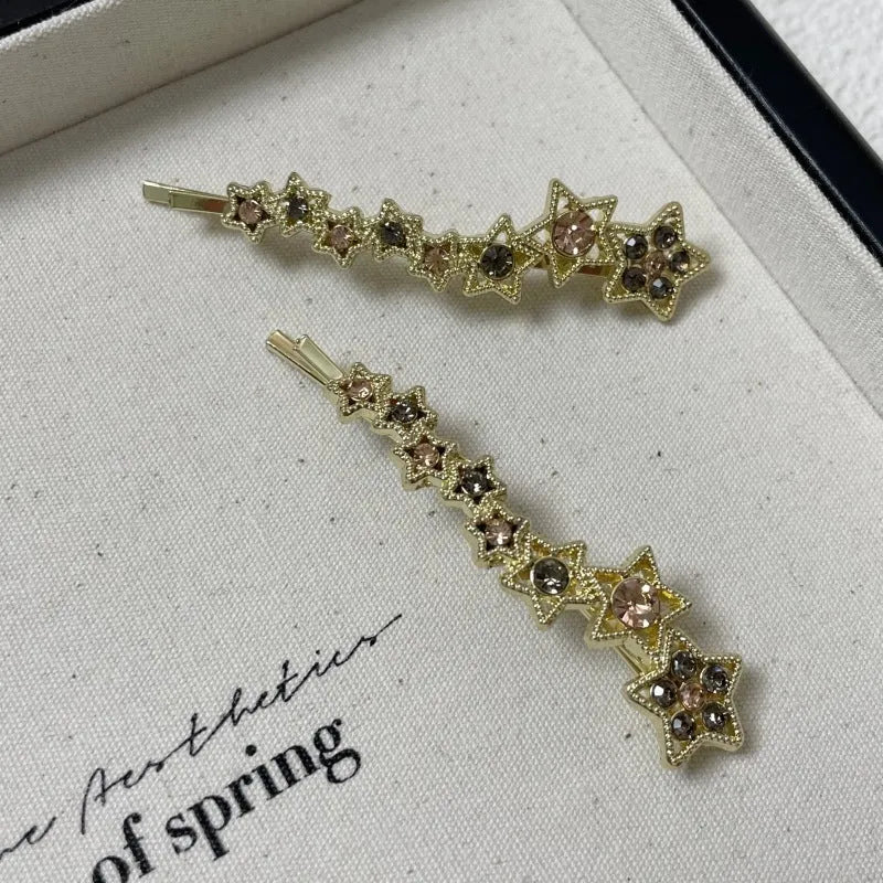 Gold-coloured alloy hair barrette with five-pointed star decoration and side-clip mechanism