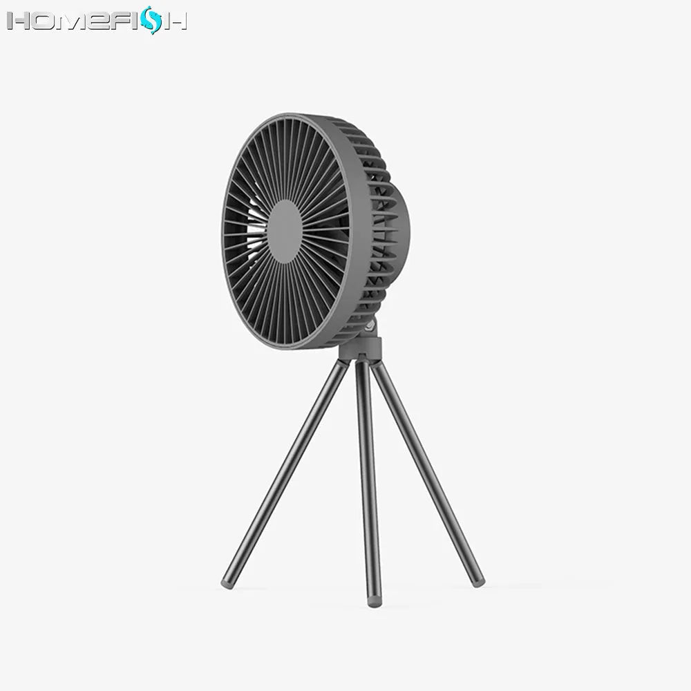 Tripod camping fan in dark grey on a wooden table showing blades and USB port