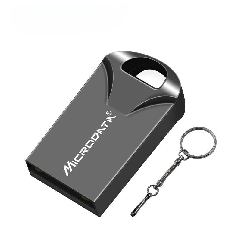 Silver car-shaped metal USB flash drive on a chain, shown next to a laptop.