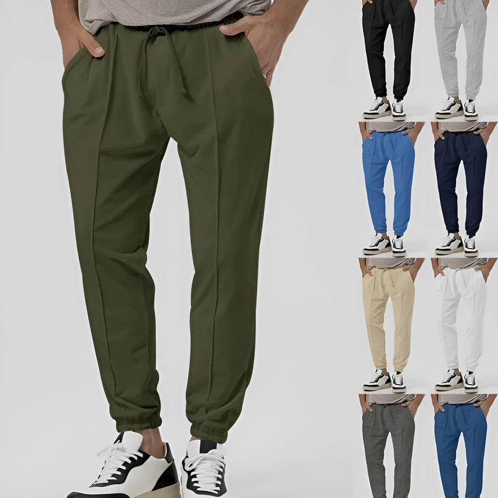 Man wearing gray straight-leg casual track sweatpants with a tapered fit and elastic waistband.