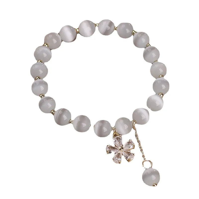 White cat's eye crystal bracelet with flower tassel charm and safety buckle closure