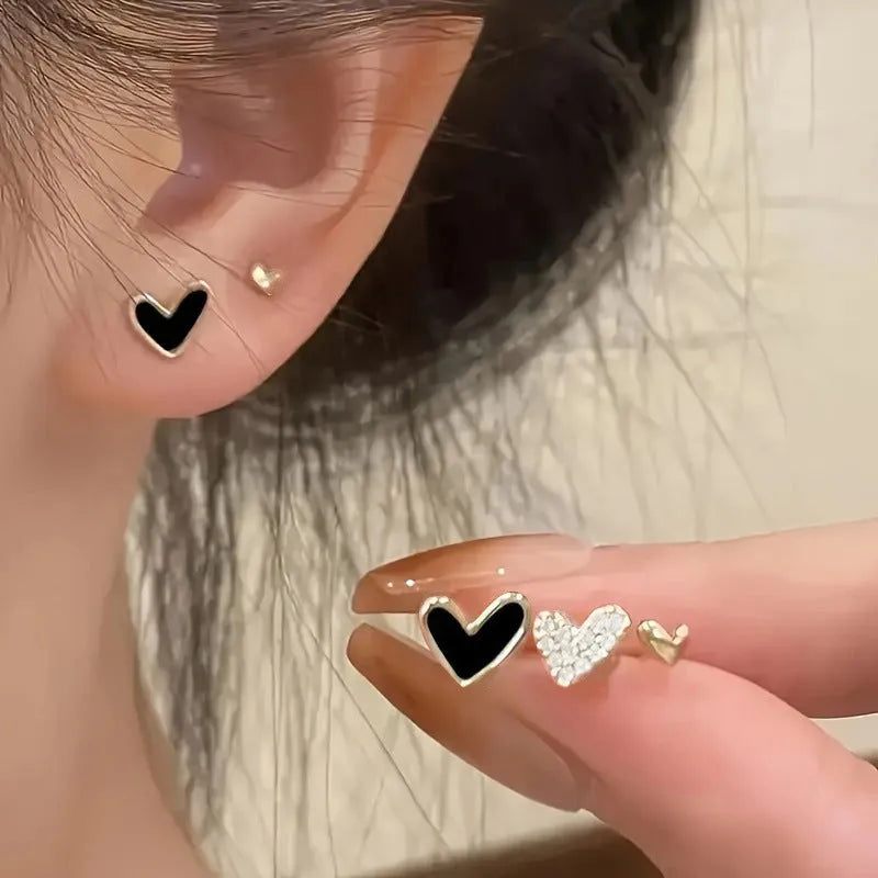 Women's heart-shaped earring set with three pairs in gold, black, black and white, and pink electroplated colours