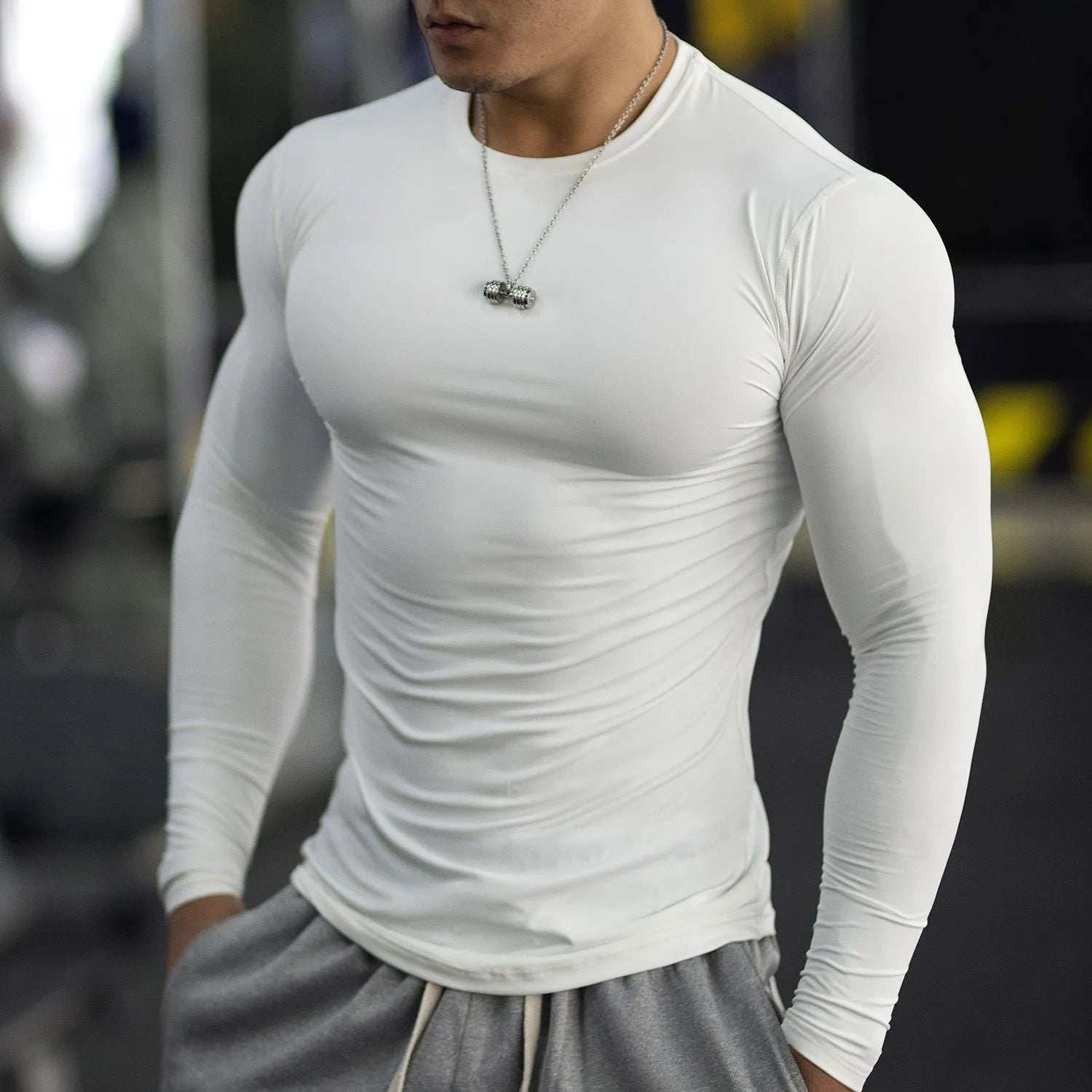 Man wearing a black slim-fit long-sleeved fitness top for running or gym workouts.