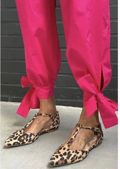 Leopard print women's pumps with pointed toe and chunky low heel, featuring cross shoulder straps