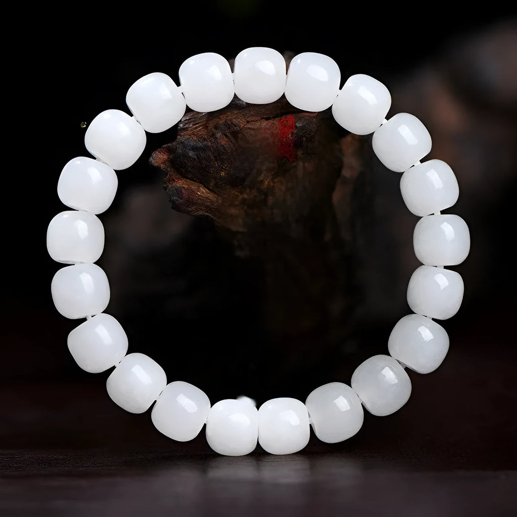 White Hetian jade barrel bead bracelet shown in three bead size variations on a wrist.