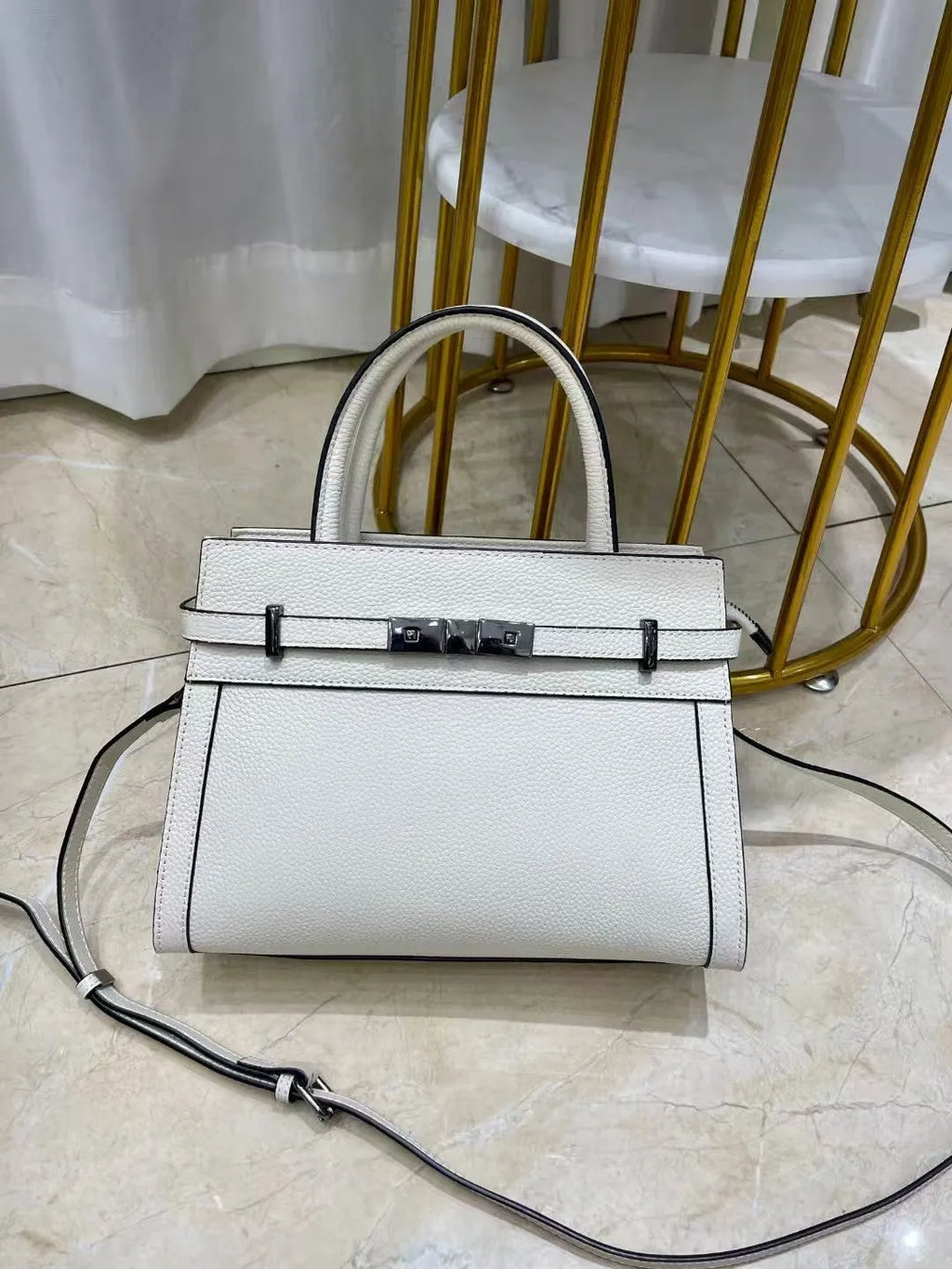 Genuine leather small square shoulder bag in almond green showing external pocket and stitching detail.