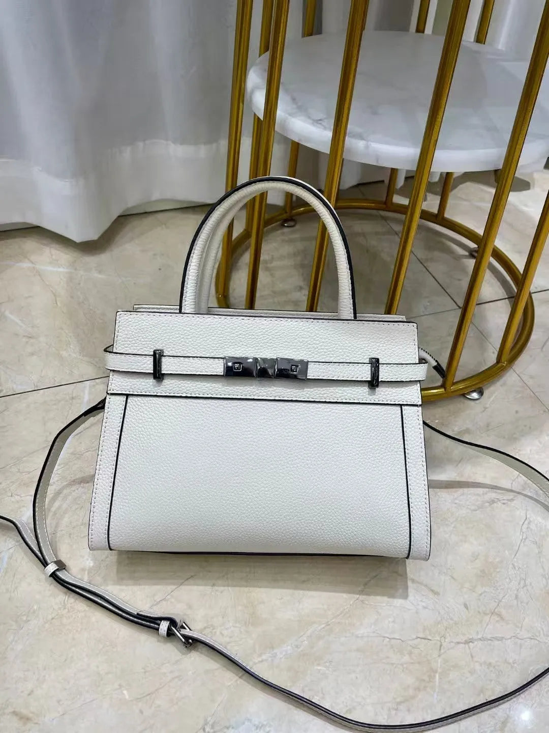 Genuine leather small square shoulder bag in almond green showing external pocket and stitching detail.