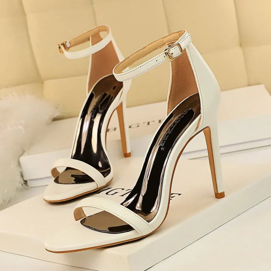 Women's ankle-strap high heel sandal in black with open toe and silver buckle.